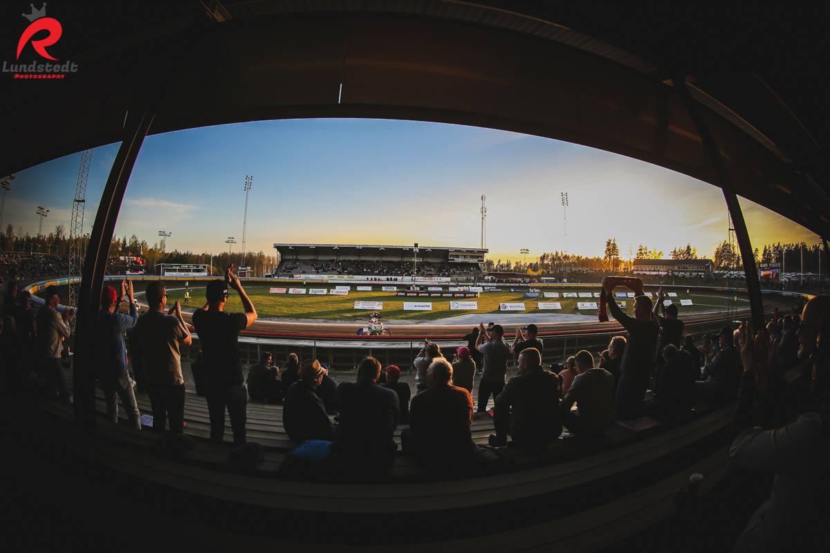 Jublande speedwayfans från lektaren ser ut över speedwaybanan