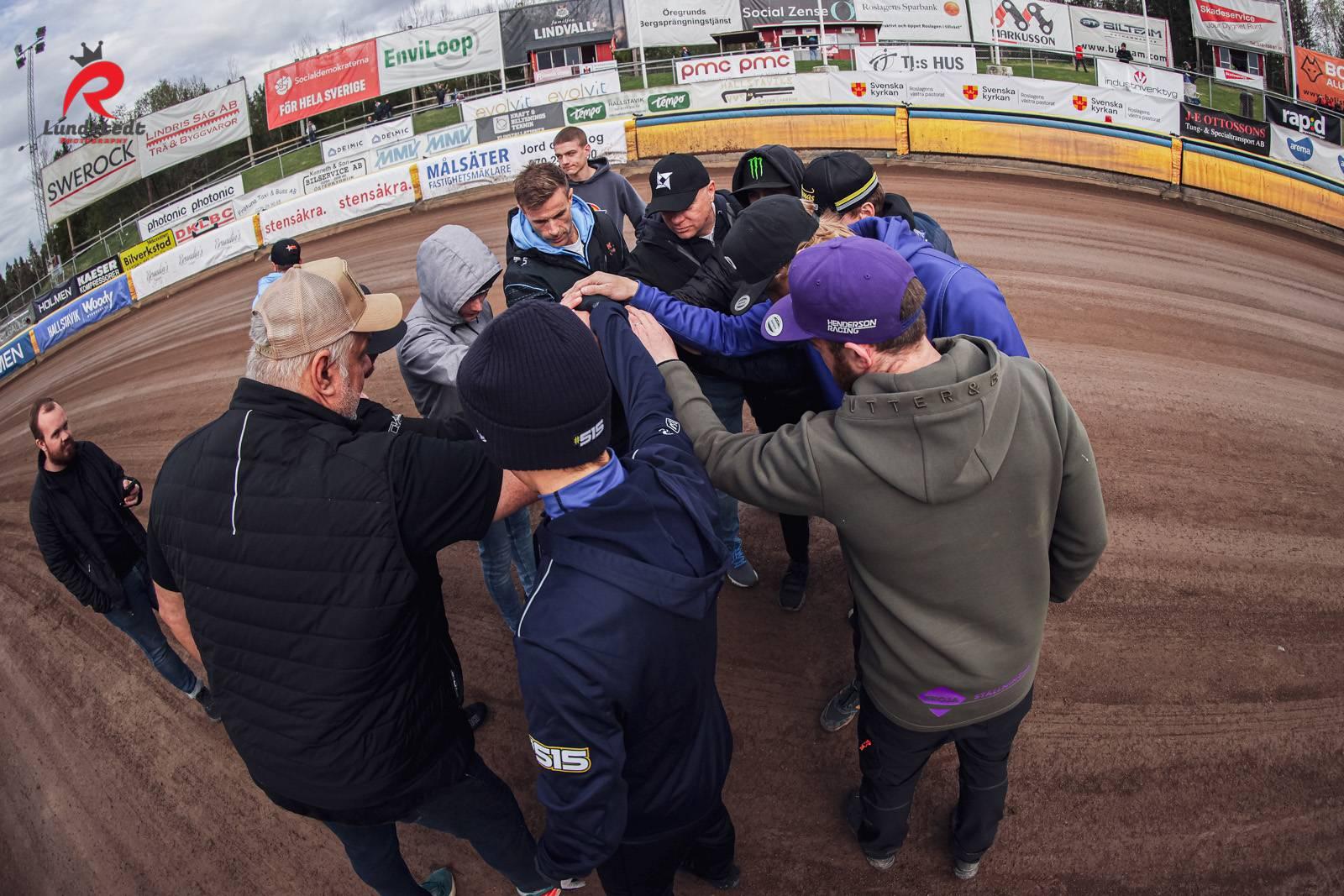 Ett Team samlat i en cirkel och lägger händerna på varandra i en lagpepp